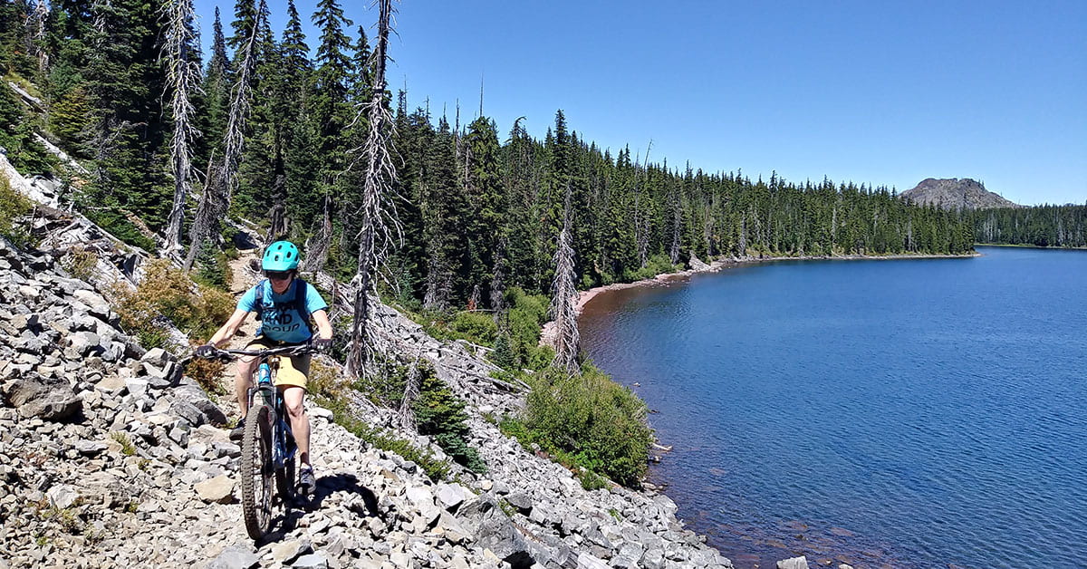 RARE Member rides mountain bike near lake