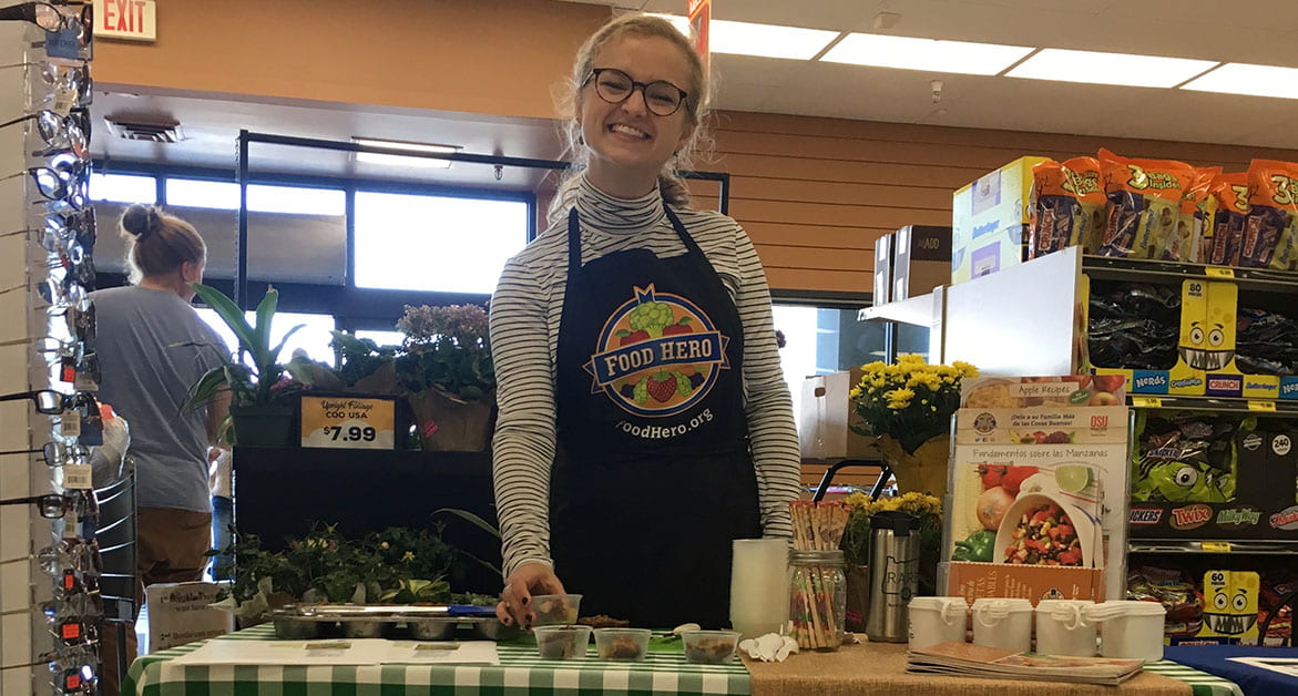RARE Member, Hannah Fuller, hosting a Food Hero demo at grocery store